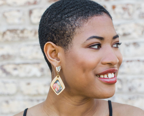 Photo of a woman wearing wood statement earrings in colors of red and green